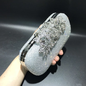 Close-up of silver evening clutch with crystal rhinestones and floral clasp detail