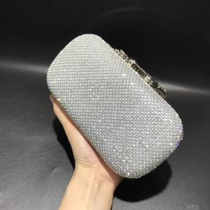 Close-up of silver rhinestone evening clutch with floral metal clasp and sparkling crystals