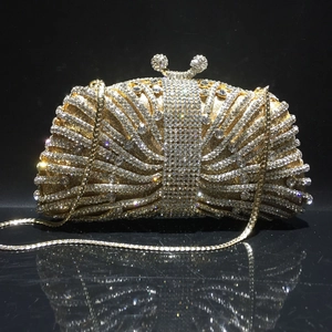 Close-up of golden evening clutch bag featuring radiant rhinestones and crystal clasp