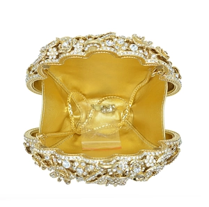 Detail of gold crystal evening clutch opening with mirrored lining and chain strap