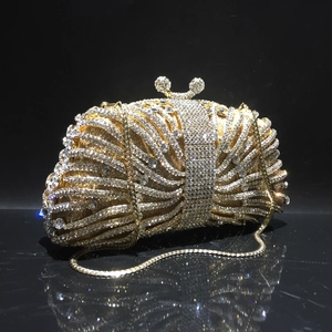 Detailed view of golden evening clutch featuring crystal rhinestones and metal chain