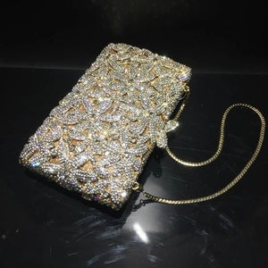 Detailed macro of crystal evening clutch bag with floral rhinestone patterns and chain