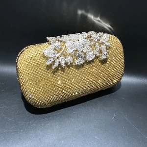 Detailed view of golden rhinestone evening clutch with silver crystal leaf clasp