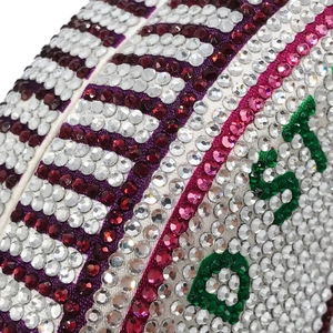 Detailed view of luxury evening bag featuring vibrant green rhinestones forming letters