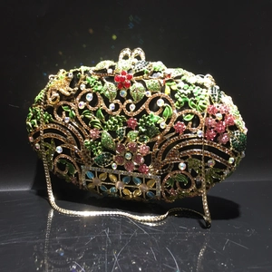 Détail d'un sac de soirée en métal évidé avec fleurs en cristal et chaîne dorée