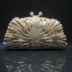 Detailed close-up of golden hollow metal frame and shimmering rhinestones on luxury clutch