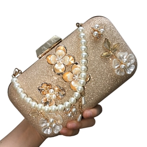Pochette de soirée dorée pailletée avec fleurs en perles et bandoulière perle