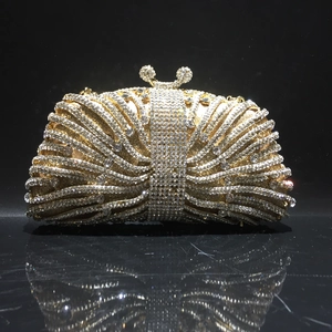 Elegant gold evening clutch bag with radiating rhinestones and crystal clasp on black base