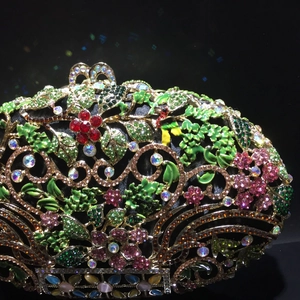 Vue détaillée de la pochette dorée ajourée avec motifs floraux en émail et strass colorés