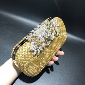 Detailed view of luxury evening clutch featuring crystal floral accents and gold rhinestones