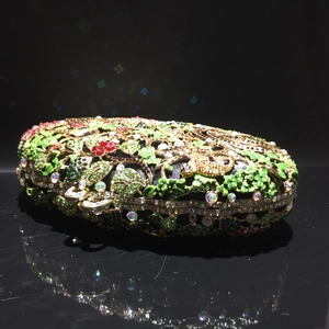 Détail du motif floral en strass sur une pochette de soirée en métal ajouré