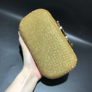 Macro shot of sparkling gold rhinestones and crystal leaf detailing on dinner clutch bag