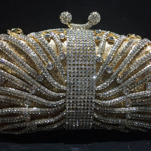 Macro view of luxury gold evening clutch featuring intricate rhinestone crystal patterns