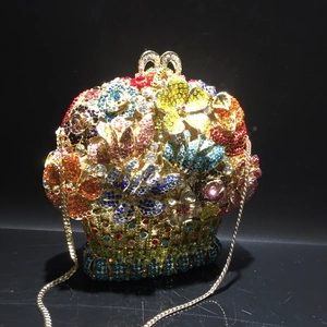 Close-up of colorful crystal floral hollow-out evening bag with gold chain strap