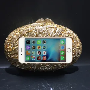 Golden rhinestone evening clutch bag with crystal accents shown fitting an iPhone 6s