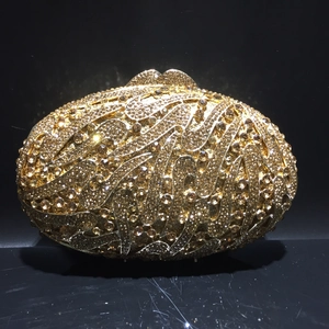 Detail of elegant gold evening clutch bag with sparkling rhinestones and metal closure