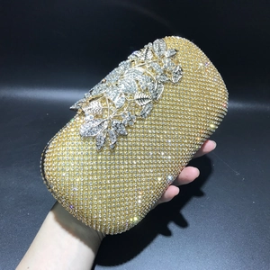 Detail of elegant evening clutch featuring full crystal leaf clasp and gold rhinestones