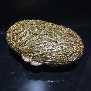 Elegant gold evening clutch bag with radiating rhinestone patterns on black background