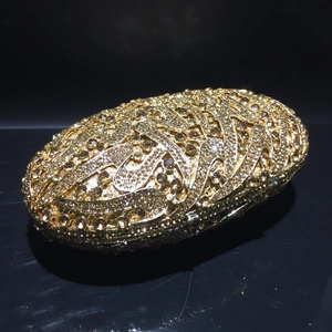 Macro shot of luxury gold rhinestone evening clutch with streamlined 3D wave texture