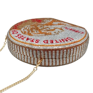 Detail of round crystal evening bag with dollar coin pattern and golden chain strap