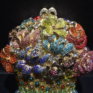 Macro shot of colorful crystals on a gold floral luxury evening clutch bag detail