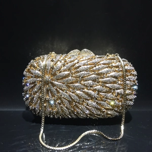 Détail de la pochette de soirée dorée avec cristaux et motifs de plumes en strass