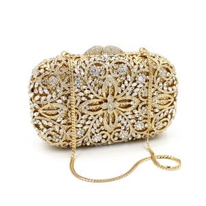 Detailed macro of gold hollow-out evening clutch with floral patterns and luxury rhinestones