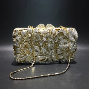 Detailansicht der goldenen Abendtasche mit floralem Strassmuster und Metall-Blattverschluss
