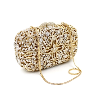 Detail of gold floral hollow metal clutch bag with sparkling rhinestones and chain