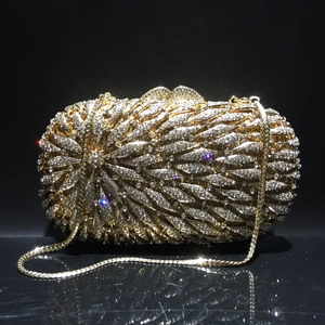 Détail d'une pochette de soirée dorée avec strass scintillants et chaîne en métal