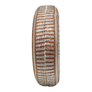 Detailed side view of striped crystal rhinestones on a circular hard shell evening clutch bag