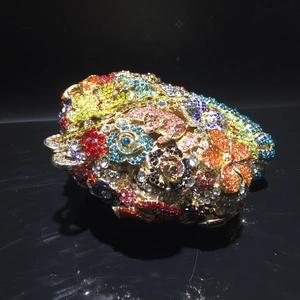 Macro shot of colorful floral crystals and gold metal details on the luxury evening clutch