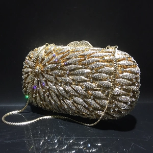 Détail d'une pochette de soirée dorée en strass avec motif de feuilles et chaîne