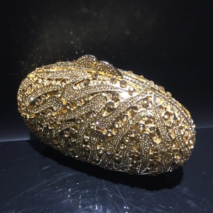 Golden rhinestone evening clutch bag with elegant wave pattern and crystal metal clasp