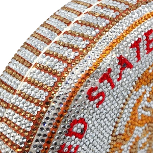 Macro view of gradient rhinestones and red inlaid STATE text on the dollar clutch bag