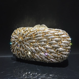 Vue détaillée d'une pochette de luxe dorée avec strass et motif de plumes étincelantes
