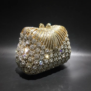 Macro detail of gold evening bag with rhinestones and sparkling bow metal clasp