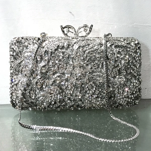 Detailed view of silver crystal evening bag with floral rhinestones and bow clasp