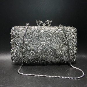 Detail of silver crystal evening clutch with sparkling rhinestones and bow metal clasp