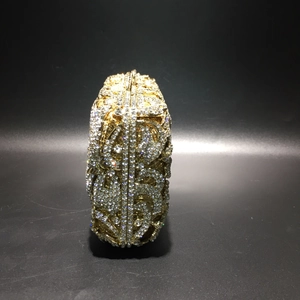 Detailansicht der luxuriösen goldenen Abendtasche mit Strasssteinen und Dollarzeichen-Muster