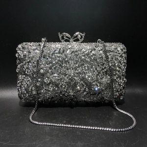 Macro shot of silver diamond evening clutch with floral patterns and butterfly clasp