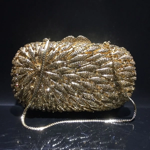 Vue macro d'une pochette dorée à strass avec texture cristal 3D et bandoulière chaîne