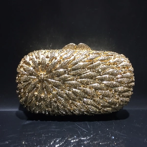 Détail de la pochette de soirée dorée au motif rayonnant de cristaux et de strass brillants