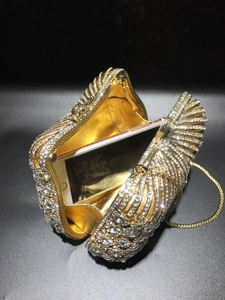Detail of gold rhinestone evening bag with chain strap and smartphone for size reference