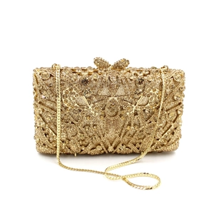 Close-up of gold evening clutch featuring crystal rhinestones and sparkling bow clasp