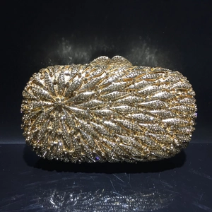 Gros plan d'une pochette de soirée dorée en strass avec motif radial et fermoir métallique