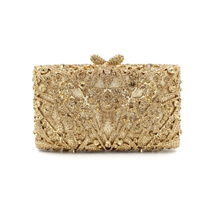 Detailed close-up of champagne gold crystal evening bag with elegant bow-shaped metal clasp