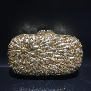 Gros plan d'une pochette dorée ornée de cristaux en forme de feuilles et de strass