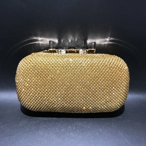 Close-up of elegant gold evening clutch bag with sparkling rhinestone surface and metal clasp