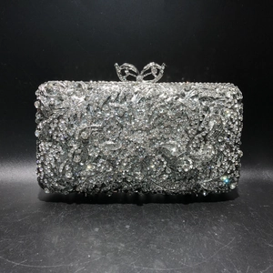 Macro shot of silver crystal evening clutch with intricate floral rhinestones and bow clasp